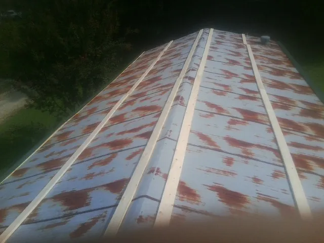 Rusted metal roof panels with new wood purlins before replacement — Storm Damage Roof Repair in Glennville by Roofing Brothers