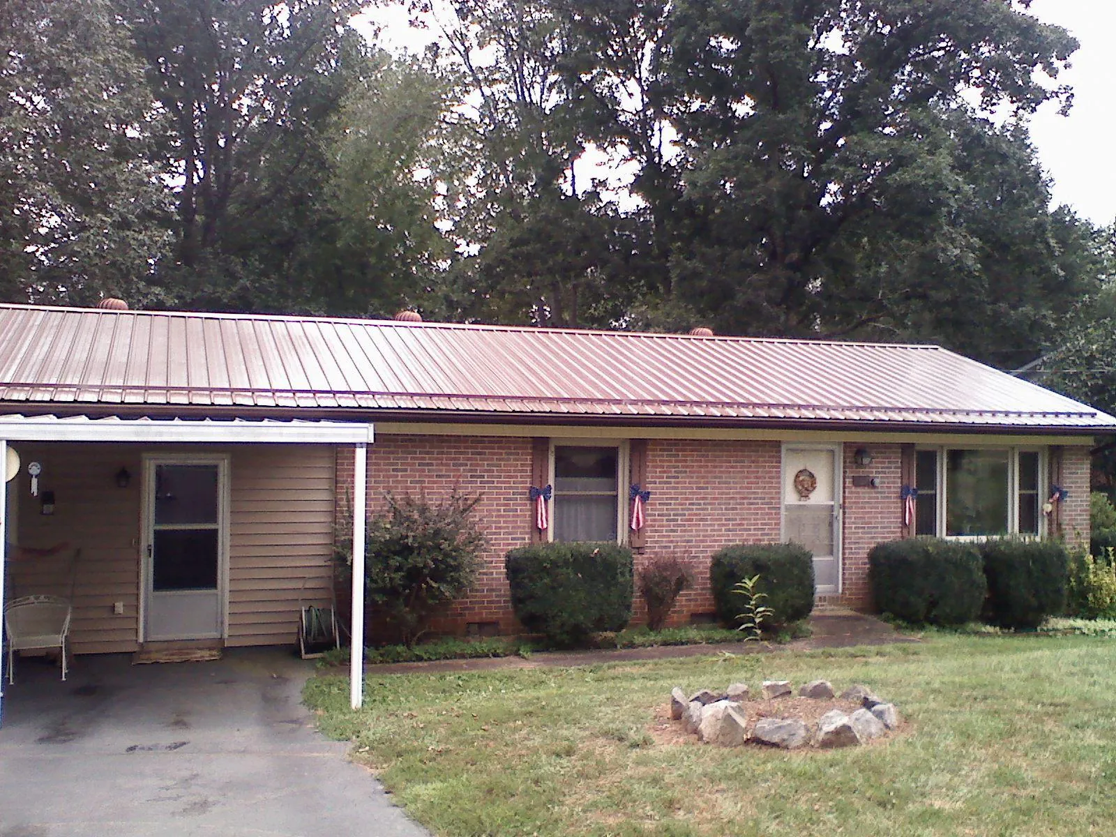 Bronze metal roof and carport on a brick ranch home — Roof Repair work by our crew in Glennville