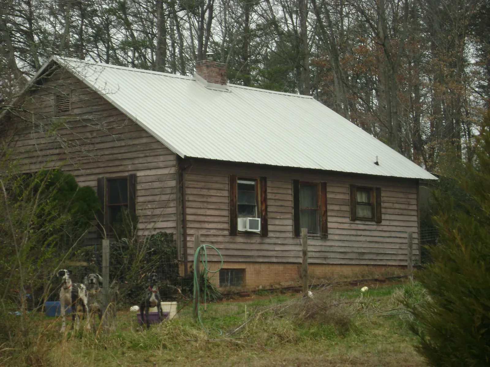 White metal roof on an old wood sided farmhouse, from a Metal Roof Installation job in Glennville